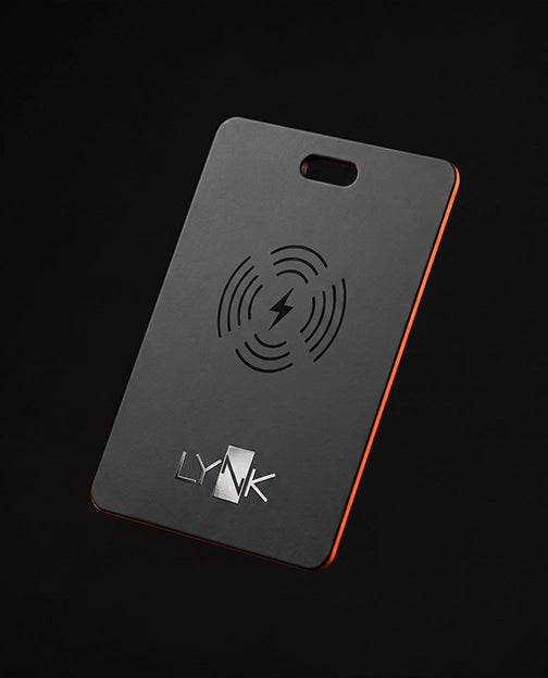 LYNK Card Tracker in matte black, angled, showing the wireless charging symbol and the LYNK logo