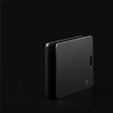 Two LYNK Card Trackers seen edge on, showing how thin the card is and the power button on the face