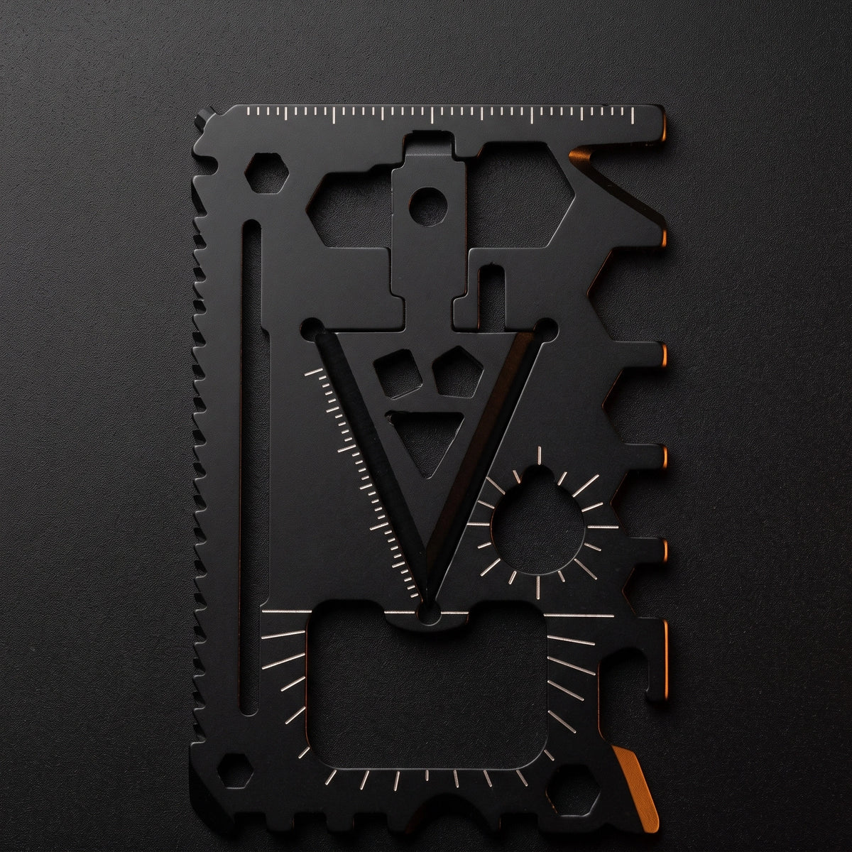 LYNK Pocket Multi-Tool Card in blackened steel lying flat on a dark surface, whole face visible
