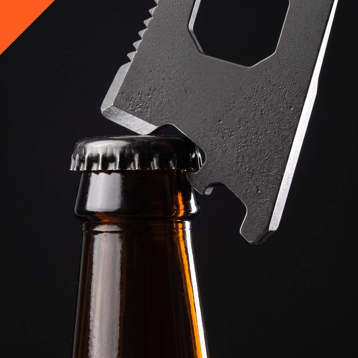 The bottle-opener notch of the LYNK Pocket Multi-Tool Card hooked under the cap of a beer bottle